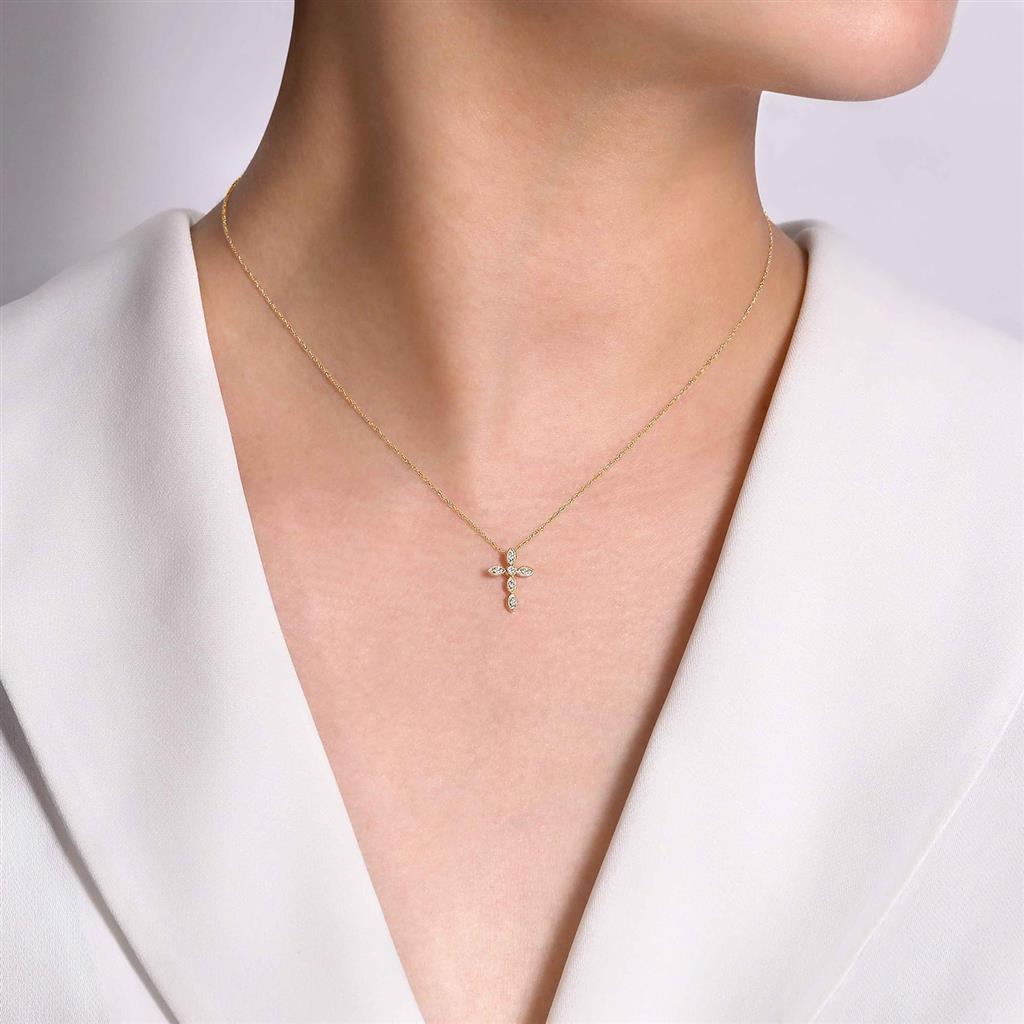 A woman wearing a Yellow Gold Diamond Cross Necklace