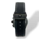Sleek contemporary watch with black rubber strap and star emblem clasp for sporty elegance.