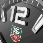 Luxury TAG Heuer watch face, featuring polished silver number 12 on a sleek black dial.