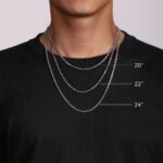 Elegant silver chains layered on a black t-shirt, showcasing modern accessory trends.